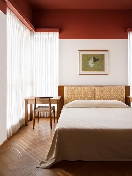 A full view of the kids' bedroom, featuring a custom bed with a patterned headboard and a matching oak wood frame. The design is symmetrical and balanced, creating a calm and orderly environment.