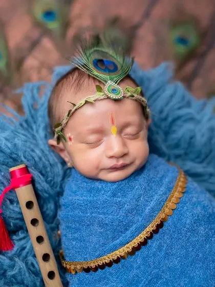 The serene expression on this baby's face perfectly captures the peaceful, divine nature of the Krishna theme.