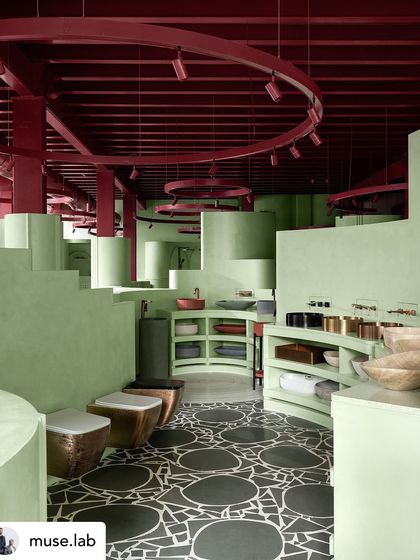 The interplay between the bold terrazzo floor and the pastel green structures creates a dynamic and immersive retail experience.