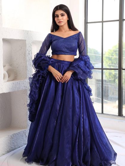 A full-length view of the royal blue organza lehenga. The combination of the simple, flowing skirt and the dramatic, detailed blouse creates a perfectly balanced look.