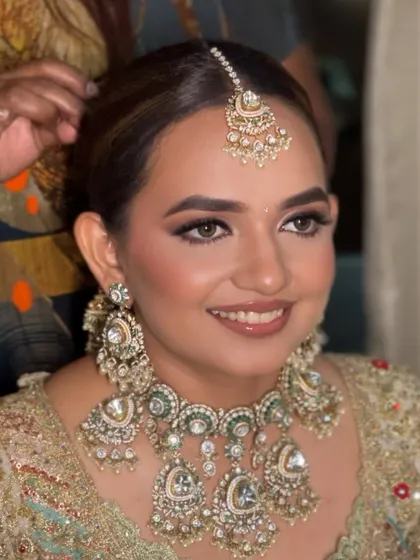 A candid moment of a bride getting ready, her hair styled in a classic floral bun. This updo is a perfect foundation for any bridal look.