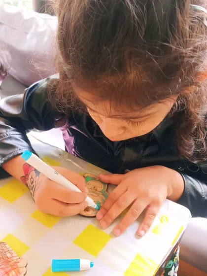 A young guest fully engaged in coloring her wooden magnet. These simple, hands-on activities are great for developing fine motor skills and concentration.