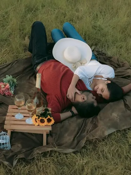 An aerial view of a romantic picnic setup in a grassy field. This type of pre-wedding shoot is perfect for capturing a relaxed and intimate story.