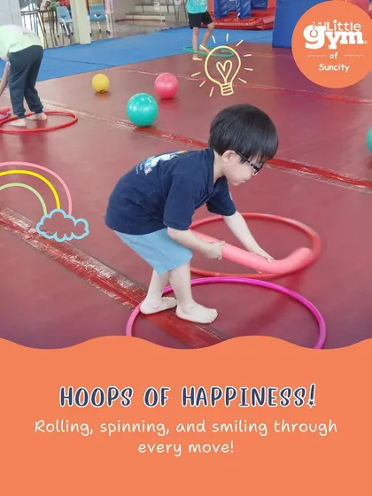 Hoops of happiness. This child is engaged in an activity with hoops and noodles, a playful exercise that enhances coordination and object manipulation skills.