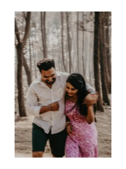 A candid moment of laughter and affection during a walk in the woods.