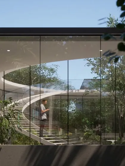 This Vastu-compliant residence in Hyderabad features a curved staircase as a central sculptural element, encased in glass to connect the home with its landscaped courtyard. The design prioritizes natural light and views, blending modern architectural forms with the principles of nature.