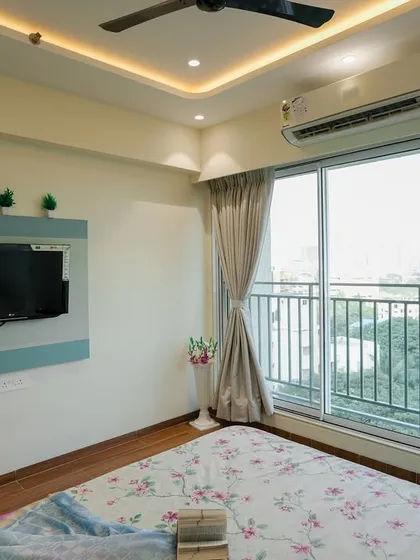 The TV wall in this bedroom is kept simple and functional, maintaining the room's serene atmosphere.