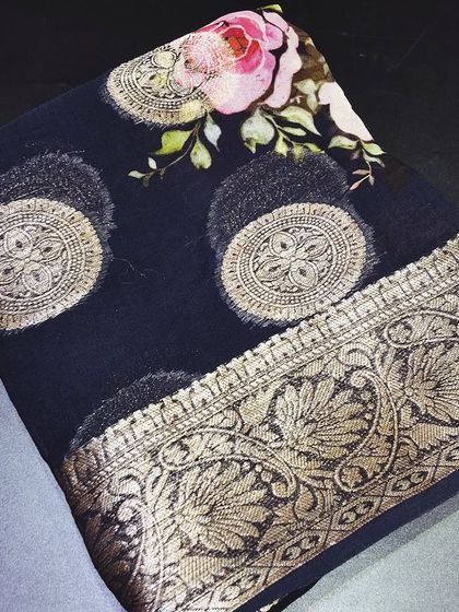A deep navy blue viscose saree with a stunning digital floral print on the pallu. The golden zari butti and border add a touch of traditional glamour to this contemporary design.