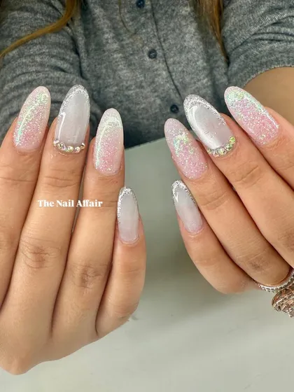 An ethereal bridal design with a sheer white base, sparkling glitter fade, and delicate pearl and rhinestone accents.