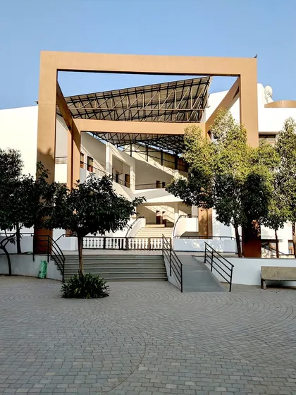 The entrance to the Vidyamandir School in Palanpur showcases our approach to creating welcoming and functional educational architecture. The design uses strong geometric forms and open, sheltered walkways that lead into the campus, providing a transition from the outside while offering protection from the elements.