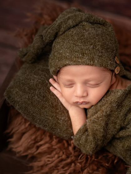 The perfect sleeping pose. This little one is so peaceful in a cozy green outfit, showing off the classic sleepy newborn look we aim for.