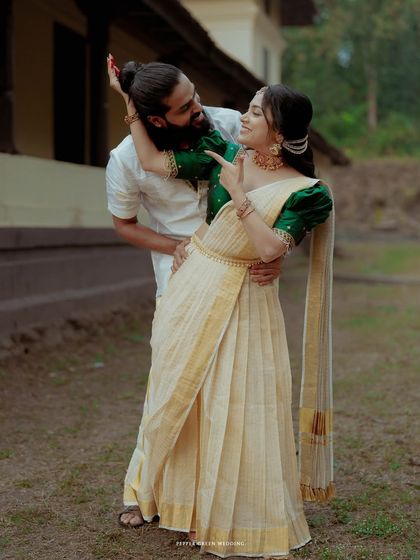 A playful and romantic moment between the bride and groom, their traditional attire shining against the rustic backdrop of Olappamanna Mana.