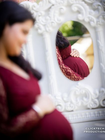 An artistic shot using a mirror to reflect the baby bump. This creative technique adds depth and a unique perspective to the maternity portrait.