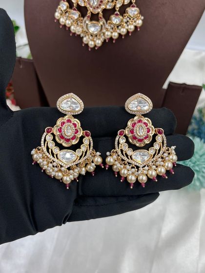 This collection showcases our premium Moissanite Kundan necklaces like the 'Noor Nazaakat' and 'Darbaar' sets. Each comes with a full set of earrings and maang tikka, available in various color combinations.