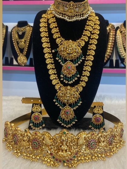 A layered temple jewellery set with green bead accents and a matching Vaddanam. This complete set provides a perfectly coordinated bridal look.