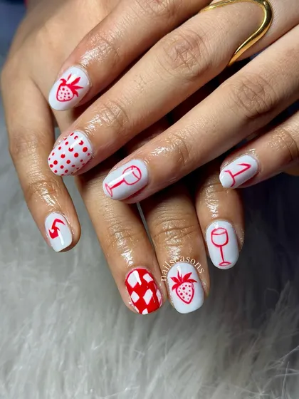 A playful set with a mix of hand-painted strawberries, wine glasses, hearts, and checkerboard patterns on a red and white base.