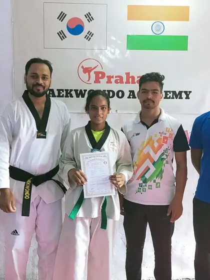 A senior green belt student, who is also a competitive athlete, after her belt promotion.