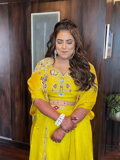 The full look of the half updo with soft waves, perfect for this bright and festive yellow outfit. It's a comfortable yet chic style for a pre wedding event.