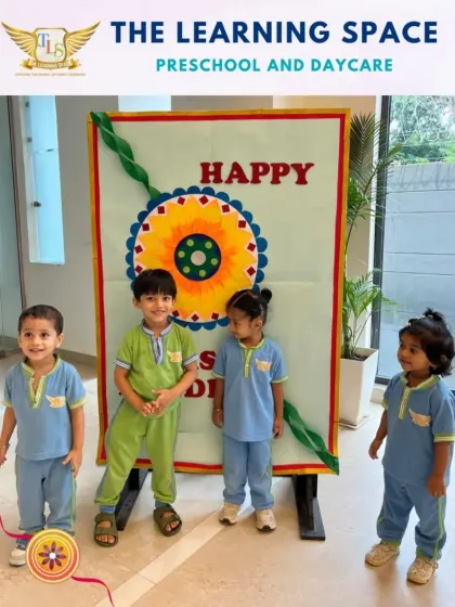 A group of children posing by the 'Happy Raksha Bandhan' sign. Celebrating festivals together helps build a strong sense of community and friendship among our learners.