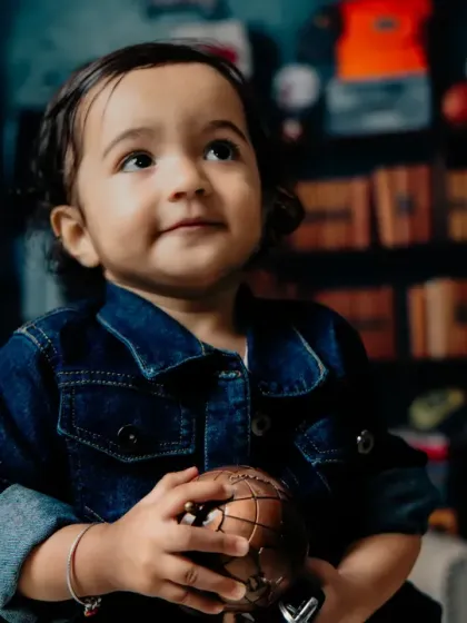 A thoughtful, upward glance from a toddler in a denim jacket. A great character shot.