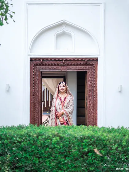 A lovely bridal portrait, framed by an ornate doorway. The composition is classic and elegant.