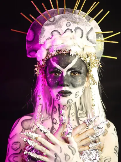 A full-body shot of the celestial character, showing the extensive body painting and the custom-made claws and headdress.
