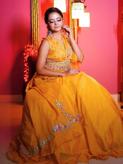 A seated portrait that highlights the intricate belt detail and the beautiful fall of the lehenga.