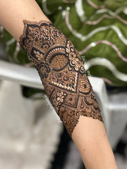 A close-up of the forearm portion of Madeeha's bridal henna, featuring a mix of geometric and floral patterns.