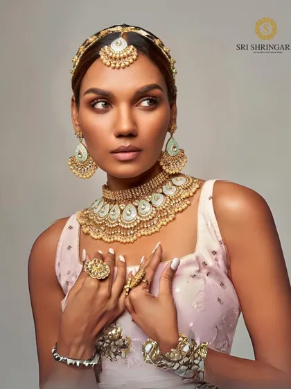 A model looking stunning in a complete Kundan set, including a choker, mathapatti, haath phool, and rings. This shows how we can provide a full head-to-toe rental solution.