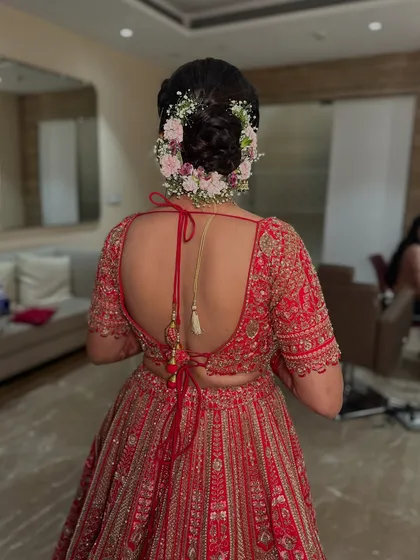My signature floral bun is a favorite among brides. This intricate hairstyle, adorned with fresh flowers, adds a touch of tradition and romance, perfectly completing the phera look.