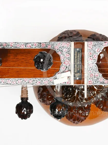 The headstock of a Pandit Ravi Shankar style sitar, featuring intricately carved pegs. These details are a signature of high-quality, handmade instruments from Miraj.