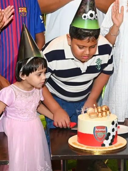 The birthday boy and his sister cutting an Arsenal-themed cake. We ensure the cake is a centerpiece that perfectly matches the party's football theme.