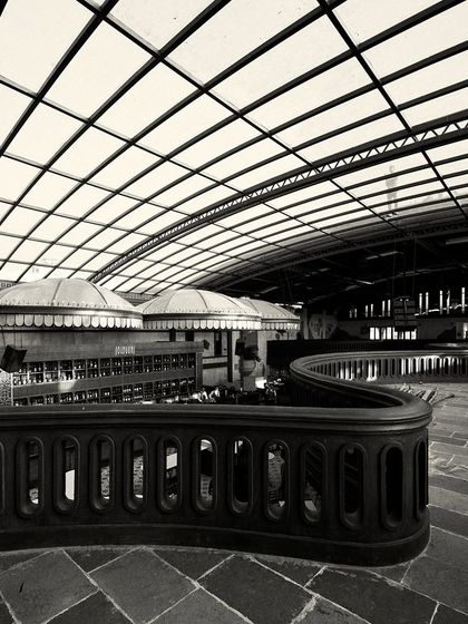This view from the end of the balcony shows the full expanse of the bar area and the grid of the glass ceiling, creating a sense of immense scale.