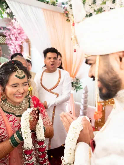 The 'varmala' exchange, with guests cheering in the background. A moment of high energy and happiness.