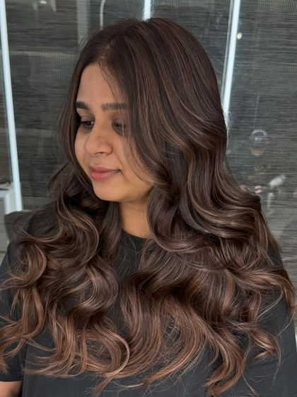 A happy client showing off her new Chestnut Brown hair color. The warm, nutty tones are blended perfectly to create a soft, natural-looking balayage effect.