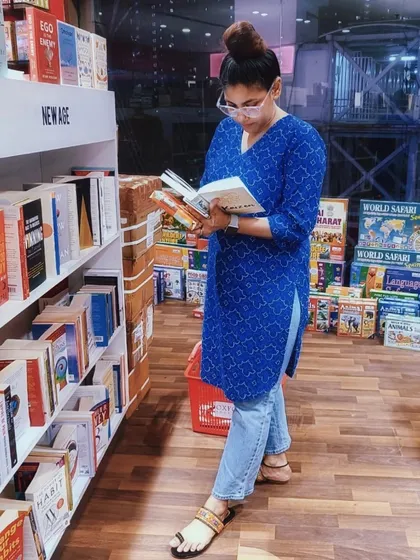 A candid shot of me browsing in a bookstore, wearing a comfortable yet stylish blue printed kurta and jeans. This shows how I incorporate ethnic wear into everyday life.