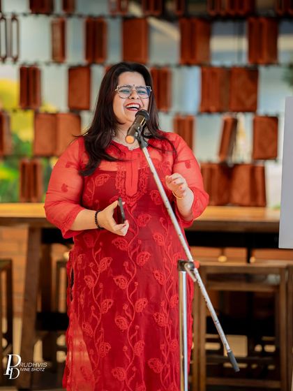A performer sharing a moment of pure joy and laughter on stage. Our open mics are spaces where every emotion is welcome, from deep introspection to uninhibited happiness.