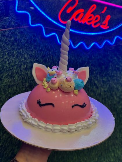 This is a fun twist on a unicorn cake, designed as a piñata cake. You can smash the chocolate dome to reveal a surprise inside, adding an interactive element to the celebration.