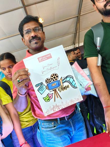 A visitor at the IDFC First Bank booth holding his personalized artwork. I combined his name with illustrations related to his interests, in this case, filmmaking.