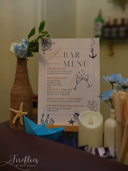 The bar menu for the nautical party, with custom-named cocktails like "The Gateway to My Heart," tying the drinks into the couple's story and the seaside location.