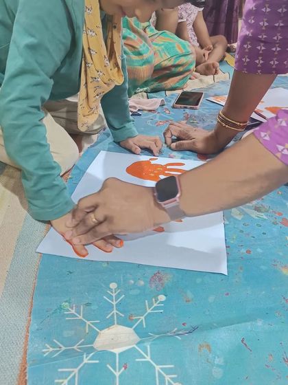 An adult helps a child make a handprint, a classic craft that is always a favorite. It's a beautiful way to capture a moment in time.