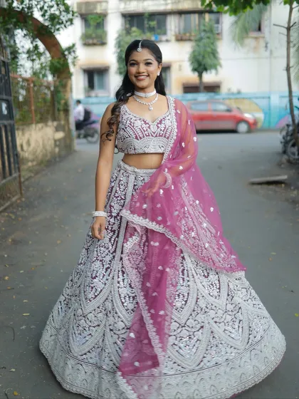 This wine-colored lehenga with heavy silver embroidery is a real head-turner. The sleeveless blouse and full skirt create a classic, elegant silhouette.