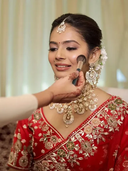 A close-up of my skin-focused technique. I believe in enhancing, not hiding. Here, I'm applying a light dusting of powder to set the makeup, ensuring the bride's natural skin texture and glow remain the hero of her wedding day look.