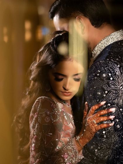 A soft, artistic portrait capturing a tender embrace. I use foreground elements to create a sense of intimacy and draw the viewer into the couple's private moment.