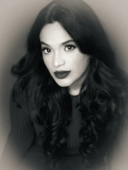 A close-up black and white portrait with a soft, dreamy effect. The focus is on the model's expressive eyes, creating an intimate and captivating image.