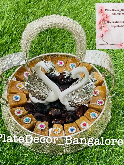 An elegant platter featuring two swan figurines, surrounded by traditional sweets and dates. This design is very popular for weddings and engagements, symbolizing love and togetherness.