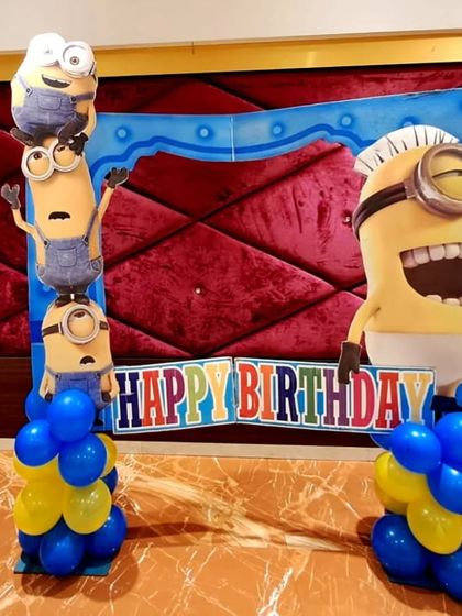 A Minions-themed photo booth with a 'Happy Birthday' sign and character cutouts. It's a perfect spot for guests to take fun pictures.