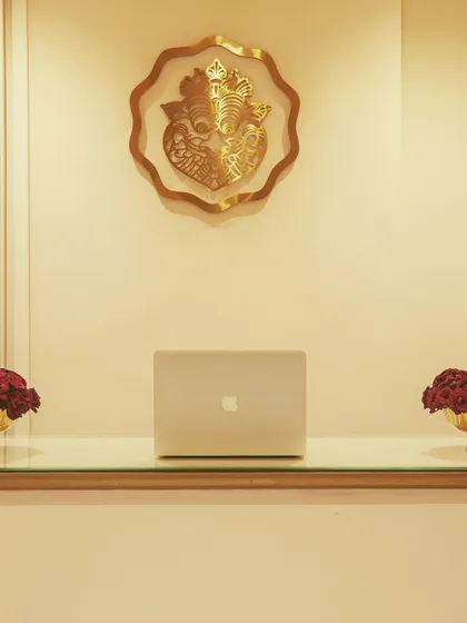 A close-up of the reception area detail, showing the blend of modern technology (a laptop) with traditional brass decor. It reflects a brand that is rooted in heritage but operates in the modern world.