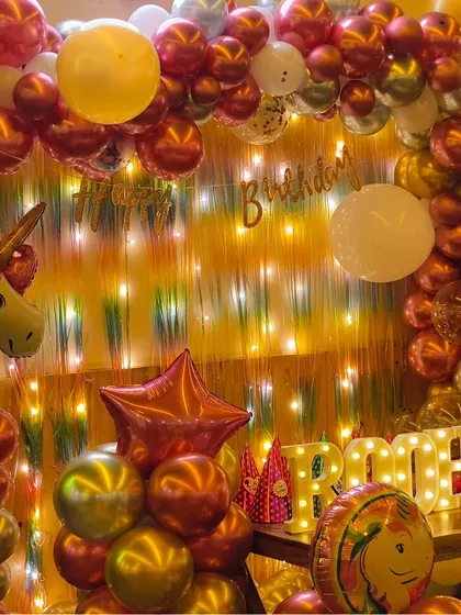 A warm and glittering unicorn-themed setup for Roohika's first birthday, using chrome balloons and fairy lights to create a magical glow.