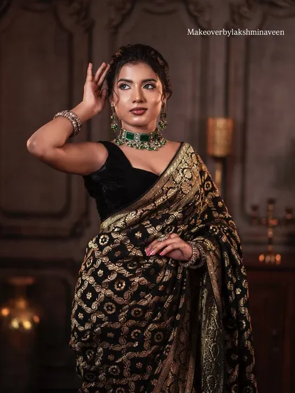 A classic pose showing the model's profile and the beautiful updo that complements the saree look.